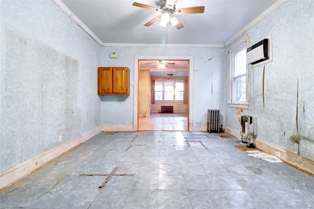 a view of a livingroom with a chandelier fan and windows