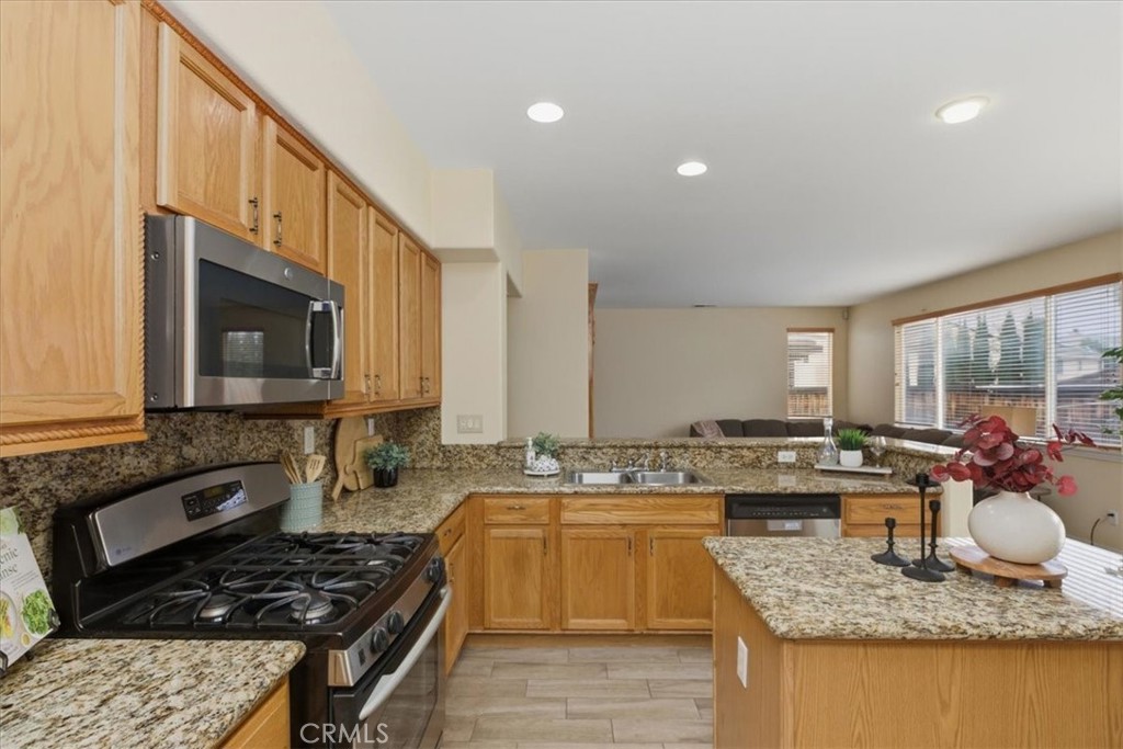 39264 Memory Drive Murrieta, CA 92563 - Photo 13 of 35 a kitchen with stainless steel appliances granite countertop a stove a sink and a microwave