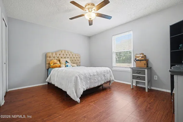 a bedroom with a bed and wooden floor