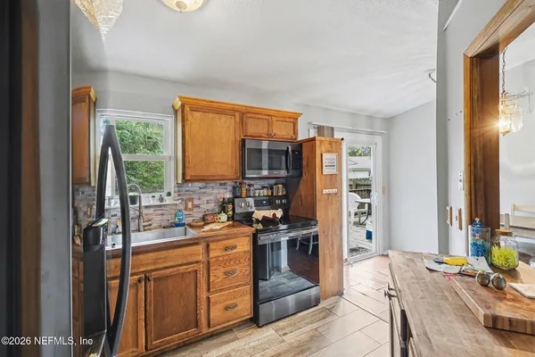 a kitchen with stainless steel appliances granite countertop a stove a sink and a refrigerator