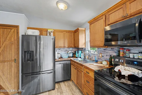 a kitchen with stainless steel appliances granite countertop a refrigerator stove top oven a sink and dishwasher