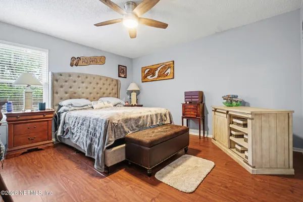 a bedroom with a bed and wooden floor