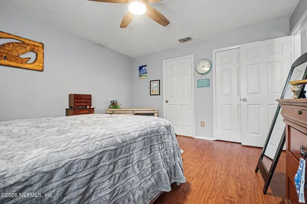 a bedroom with bed and wooden floor