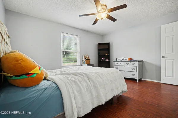 a bedroom with a bed and wooden floor