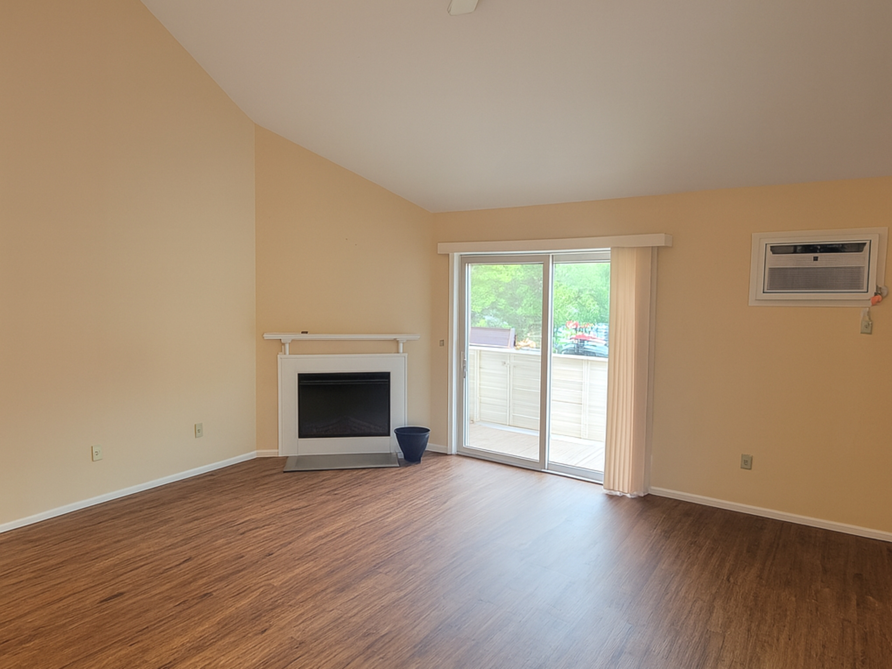 52 Willow Springs, Unit 52 New Milford, CT 06776 - Photo 2 of 14 an empty room with wooden floor fireplace and windows