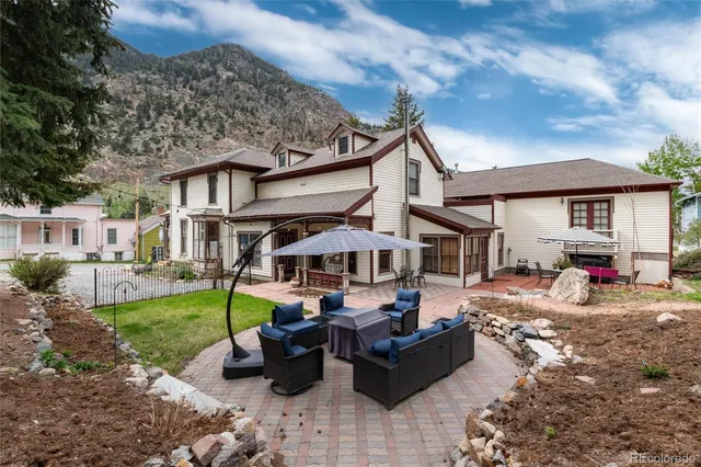 a view of a house with backyard and sitting area