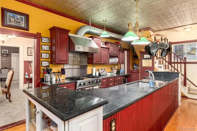 a kitchen with stainless steel appliances granite countertop a sink a counter and chairs