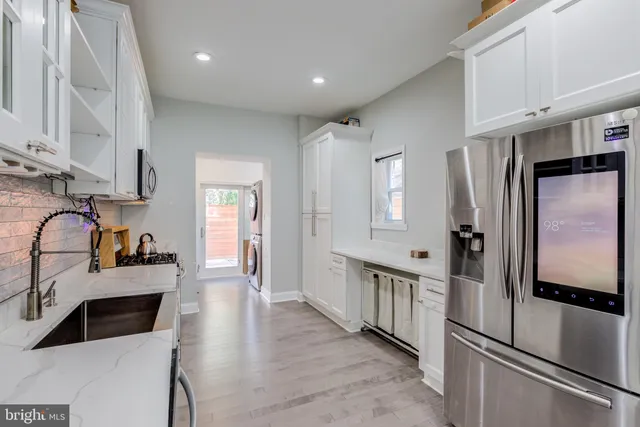 a kitchen with stainless steel appliances a refrigerator sink and cabinets