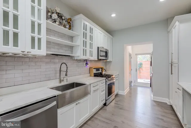 a kitchen with stainless steel appliances granite countertop a sink stove and cabinets