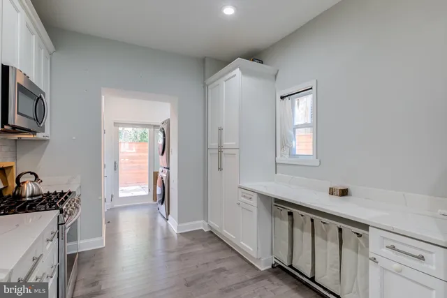 a kitchen that has a lot of cabinets in it and wooden floors