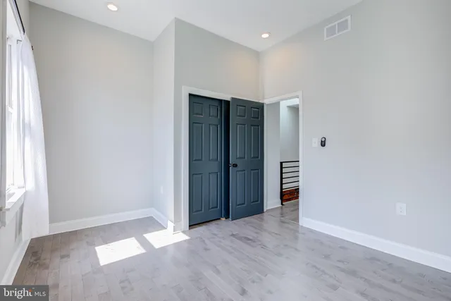 an empty room with closet and wooden floor