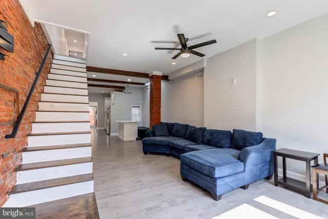 a living room with furniture and a ceiling fan