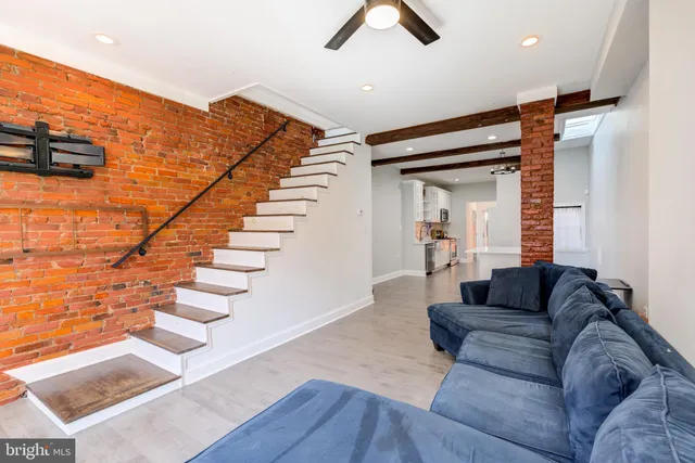 a living room with furniture and stairs