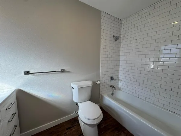 a white toilet sitting next to a bathtub
