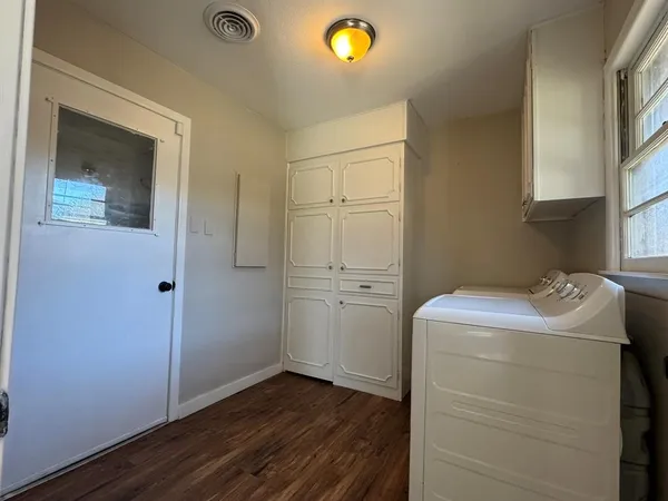 a view of utility room with closet and wooden floor