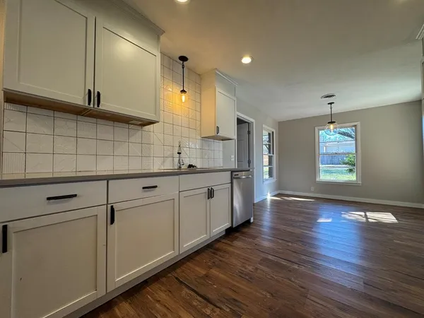 a kitchen with granite countertop white cabinets and white appliances