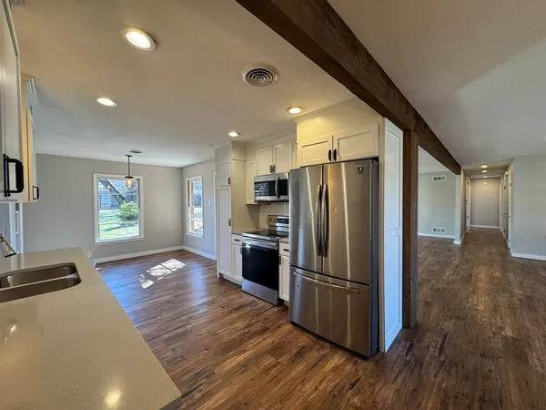 a kitchen with stainless steel appliances a refrigerator and a stove top oven
