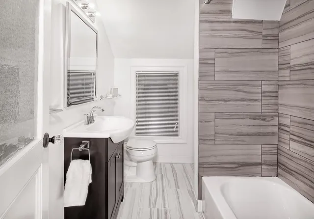 a bathroom with a sink a toilet and shower