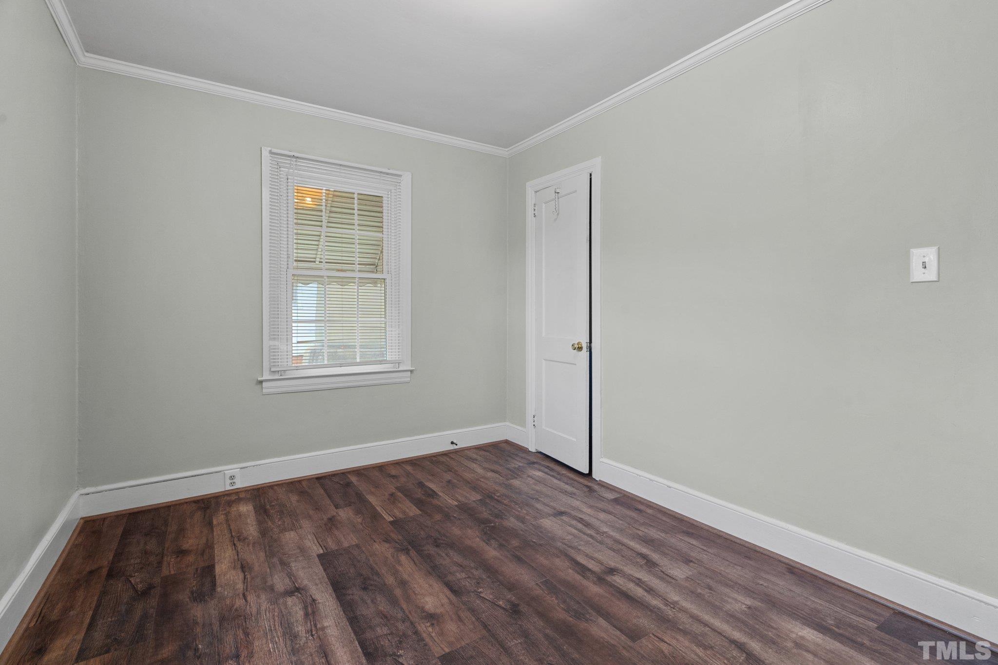203 Spring Street Louisburg, NC 27549 - Photo 11 of 23 an empty room with wooden floor and windows