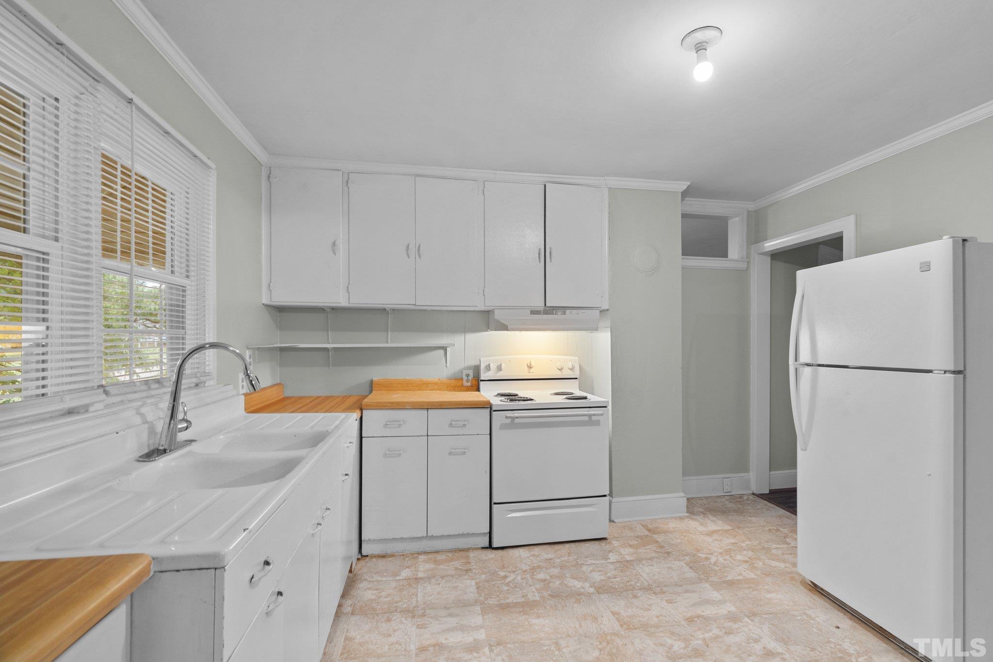 203 Spring Street Louisburg, NC 27549 - Photo 16 of 23 a kitchen with a sink a refrigerator and cabinets
