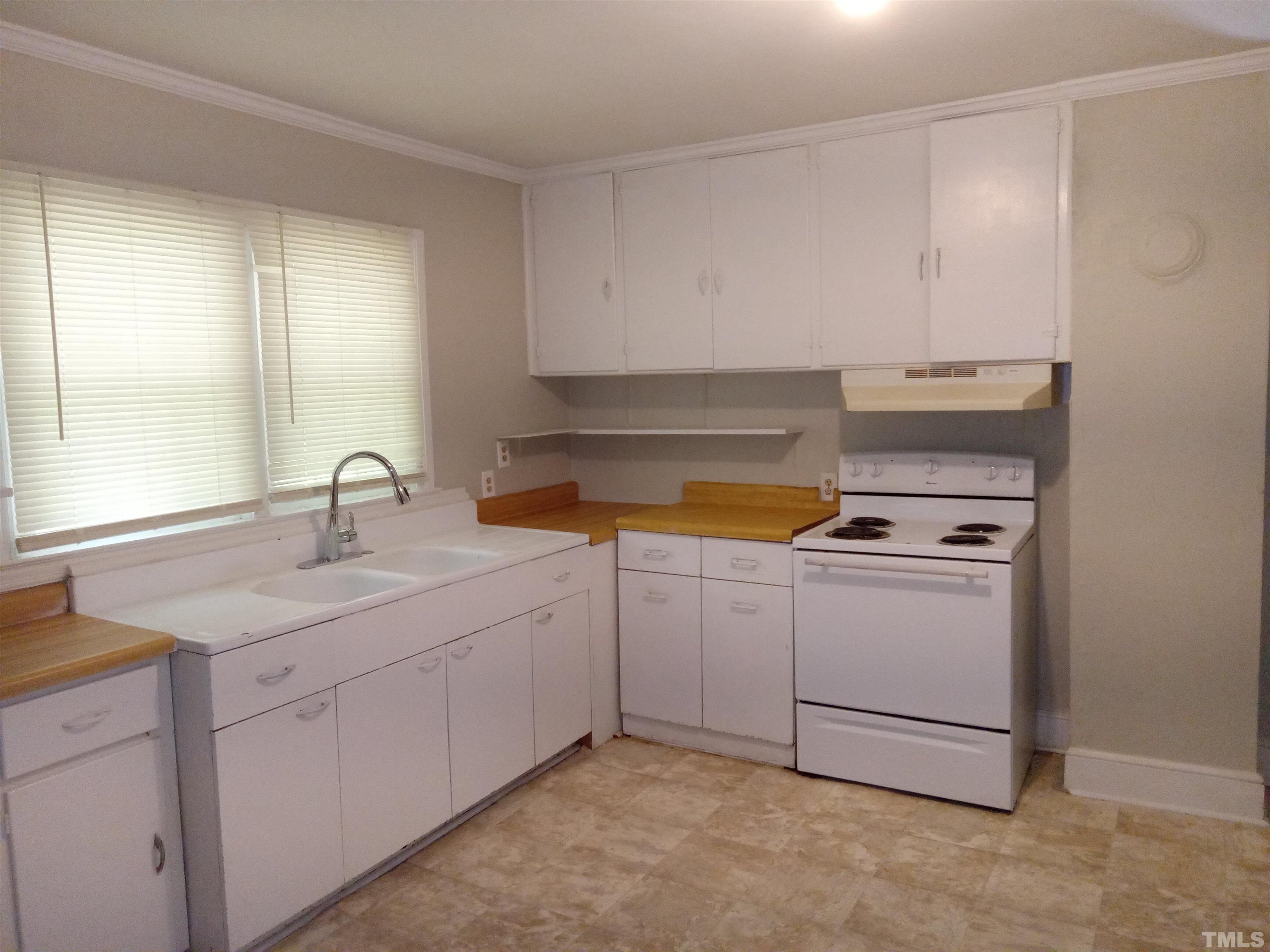 203 Spring Street Louisburg, NC 27549 - Photo 3 of 23 a kitchen with cabinets and white appliances