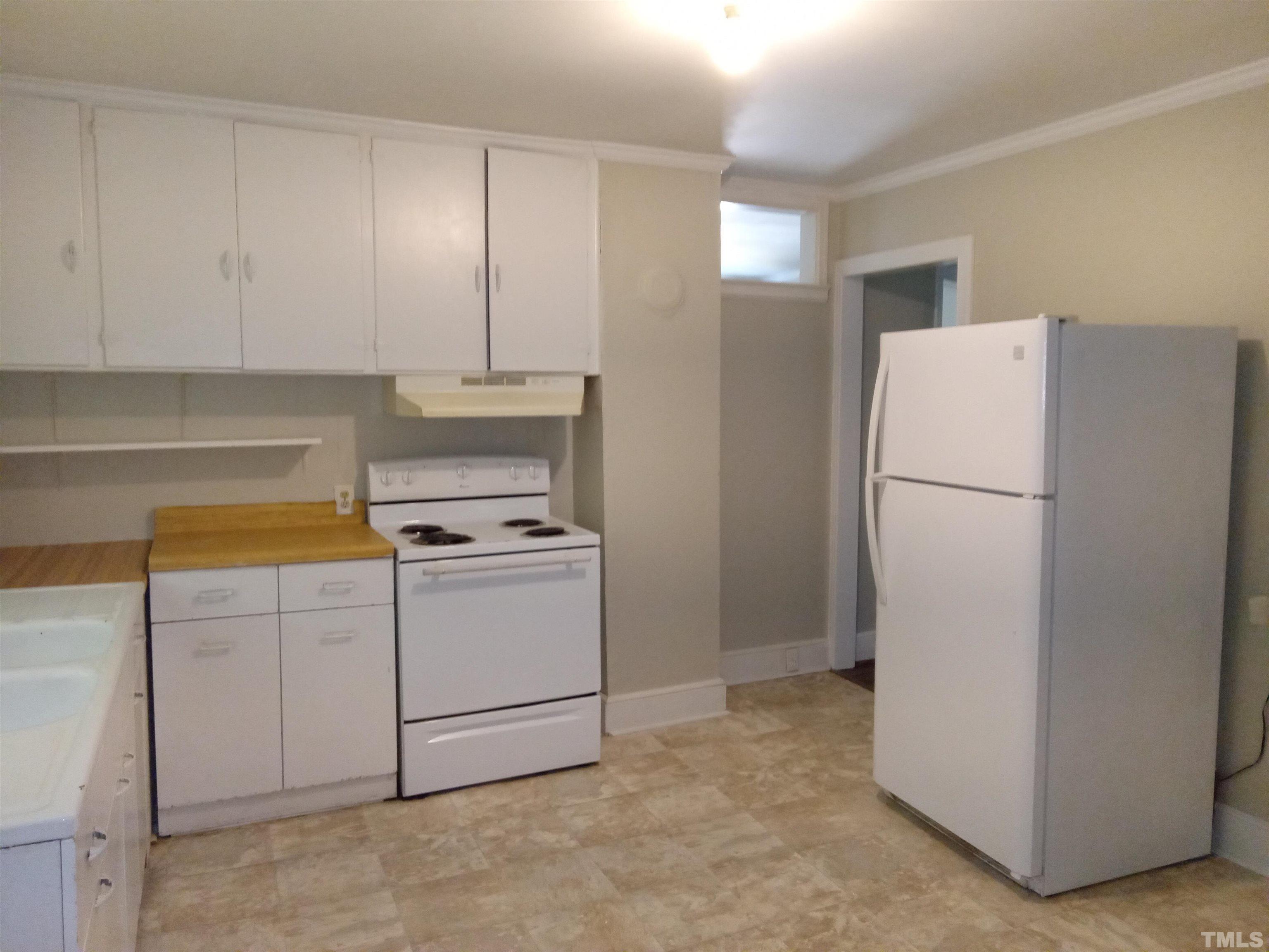203 Spring Street Louisburg, NC 27549 - Photo 4 of 23 a white refrigerator freezer and a stove in a kitchen