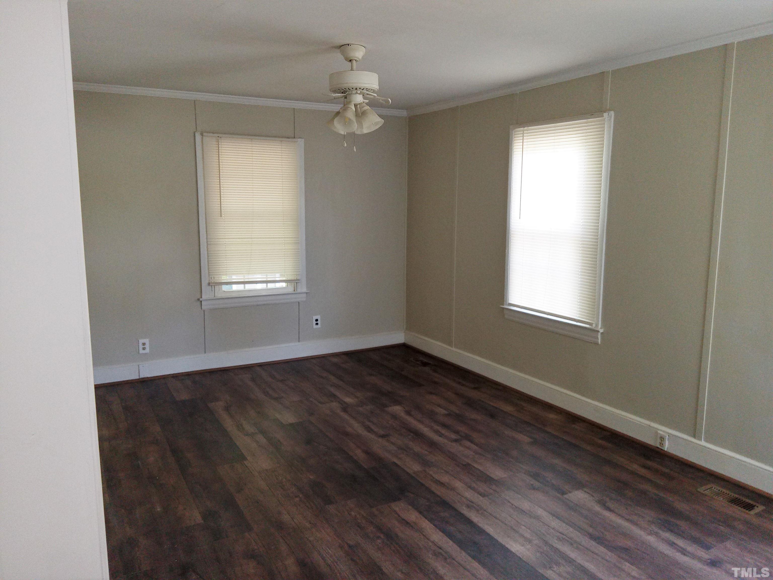 203 Spring Street Louisburg, NC 27549 - Photo 5 of 23 a view of an empty room with wooden floor and a window