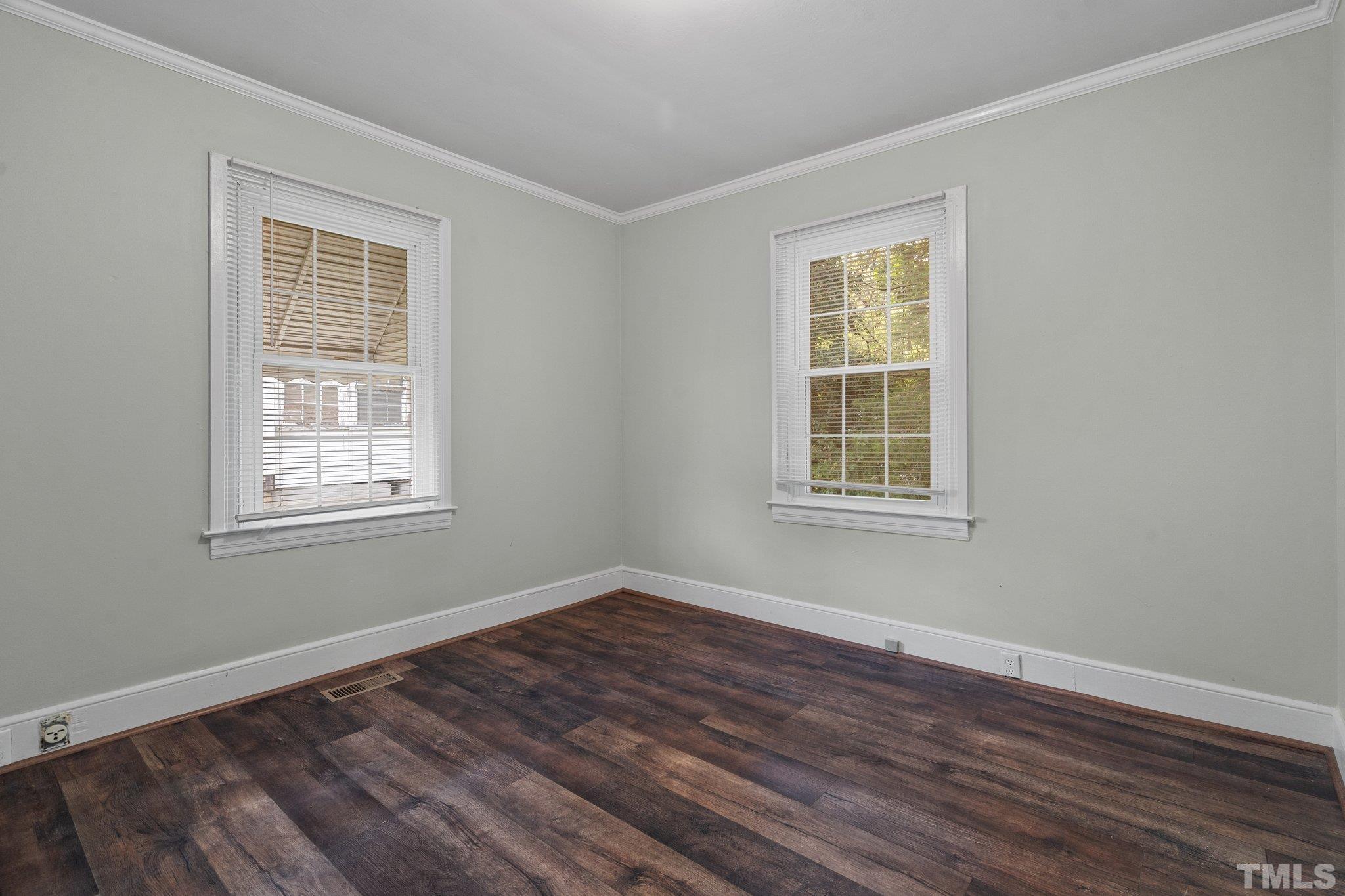 203 Spring Street Louisburg, NC 27549 - Photo 8 of 23 a view of an empty room with wooden floor and a window