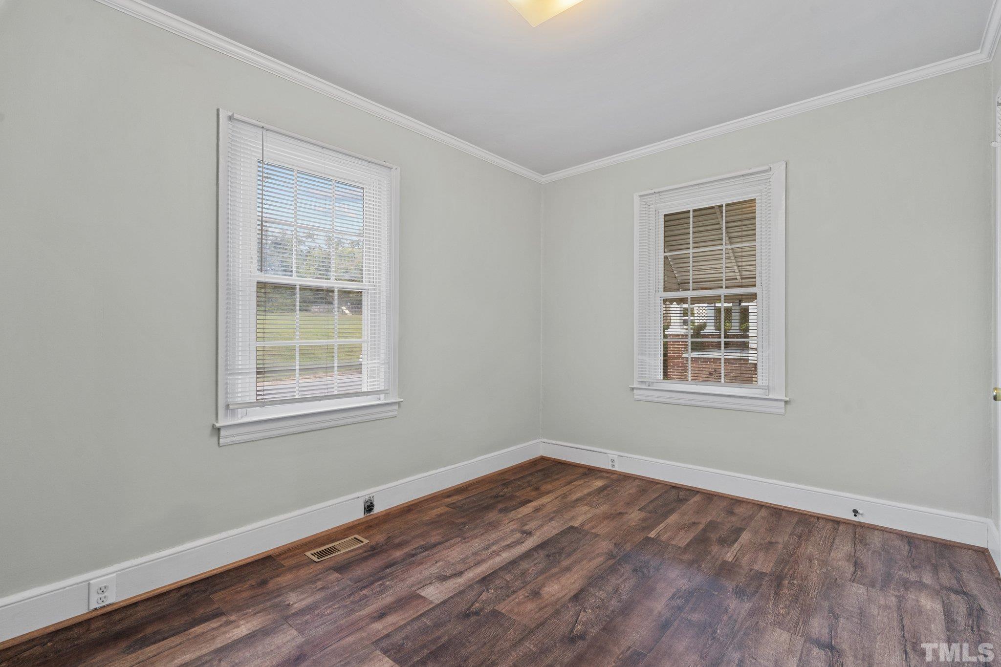 203 Spring Street Louisburg, NC 27549 - Photo 10 of 23 an empty room with wooden floor and windows