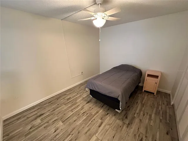 a living room with hard wood floors and a ceiling fan