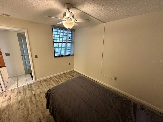 a view of a bedroom with a bed and wooden floor
