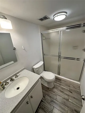 a bathroom with a sink mirror vanity and toilet