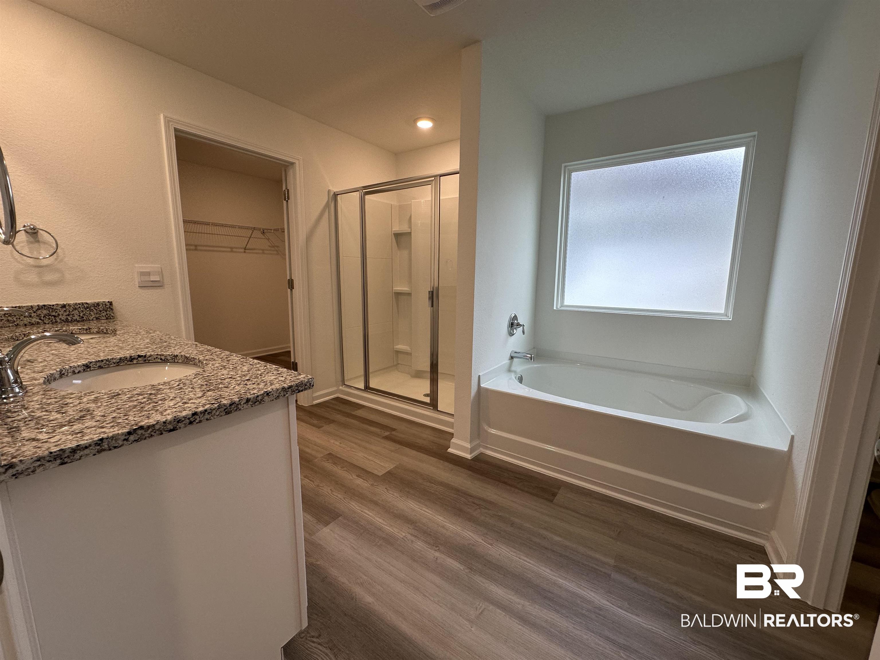 22275 Aleutian Avenue Foley, AL 36535 - Photo 17 of 72 Bathroom featuring vanity, plus walk in shower, and wood-type flooring