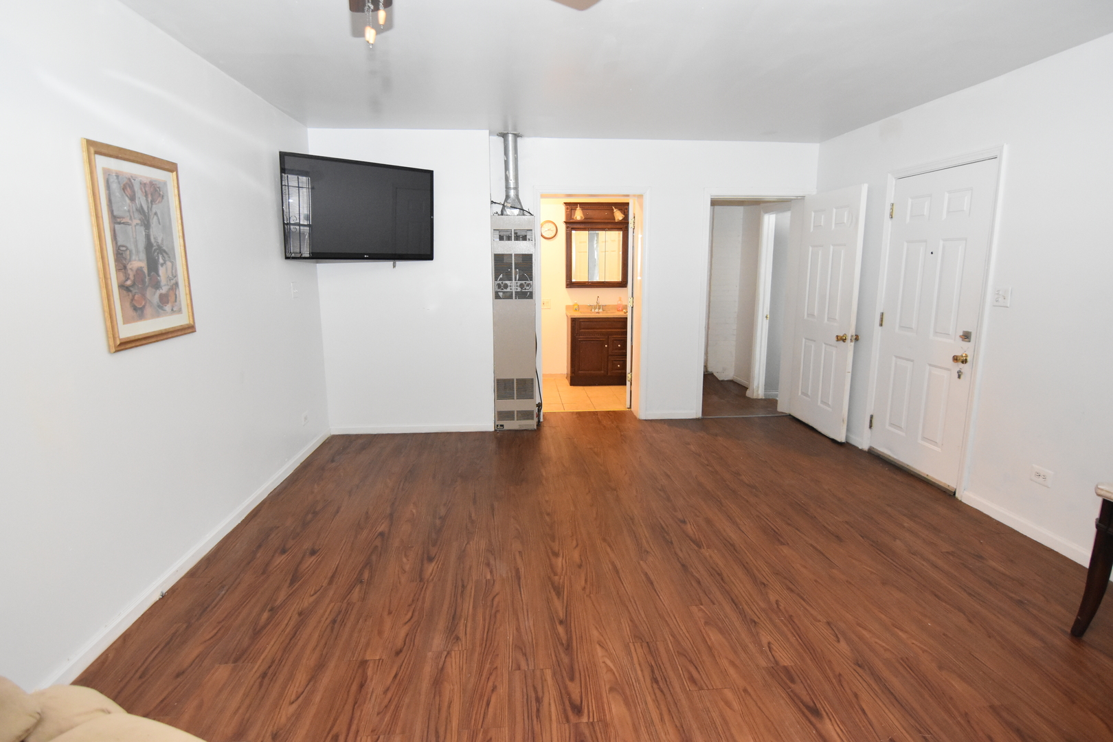 141 West 124th Street Chicago, IL 60628 - Photo 16 of 26 a view of a livingroom with wooden floor and a flat screen tv