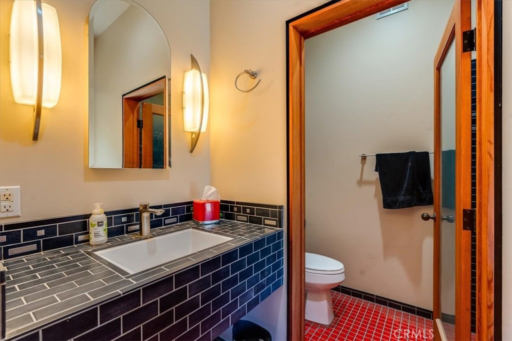 1604 Tiffany Ranch Road Arroyo Grande, CA 93420 - Photo 19 of 32 a bathroom with a granite countertop sink toilet a mirror and shower