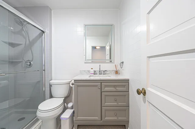 a bathroom with a granite countertop toilet a sink and a mirror