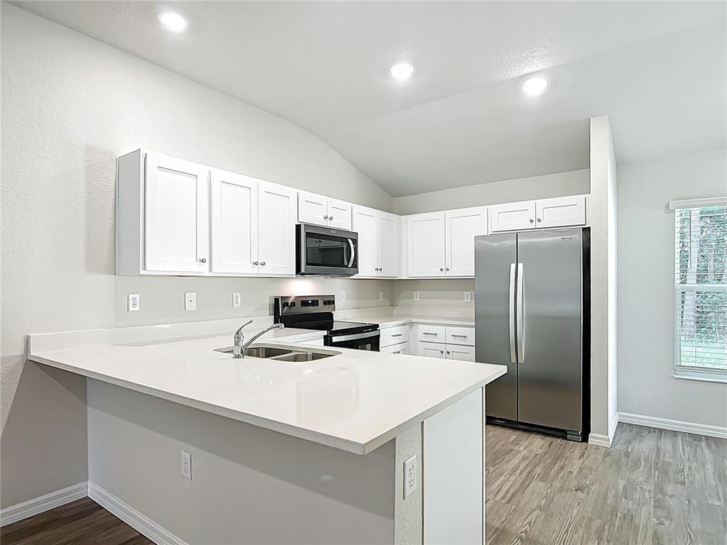 827 Hickory Avenue Inverness, FL 34452 - Photo 3 of 9 a kitchen with stainless steel appliances a refrigerator sink and microwave