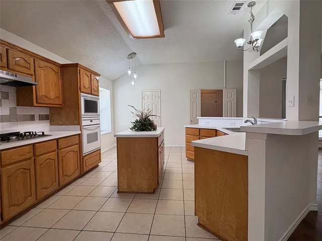 a large kitchen with kitchen island a sink stainless steel appliances and cabinets