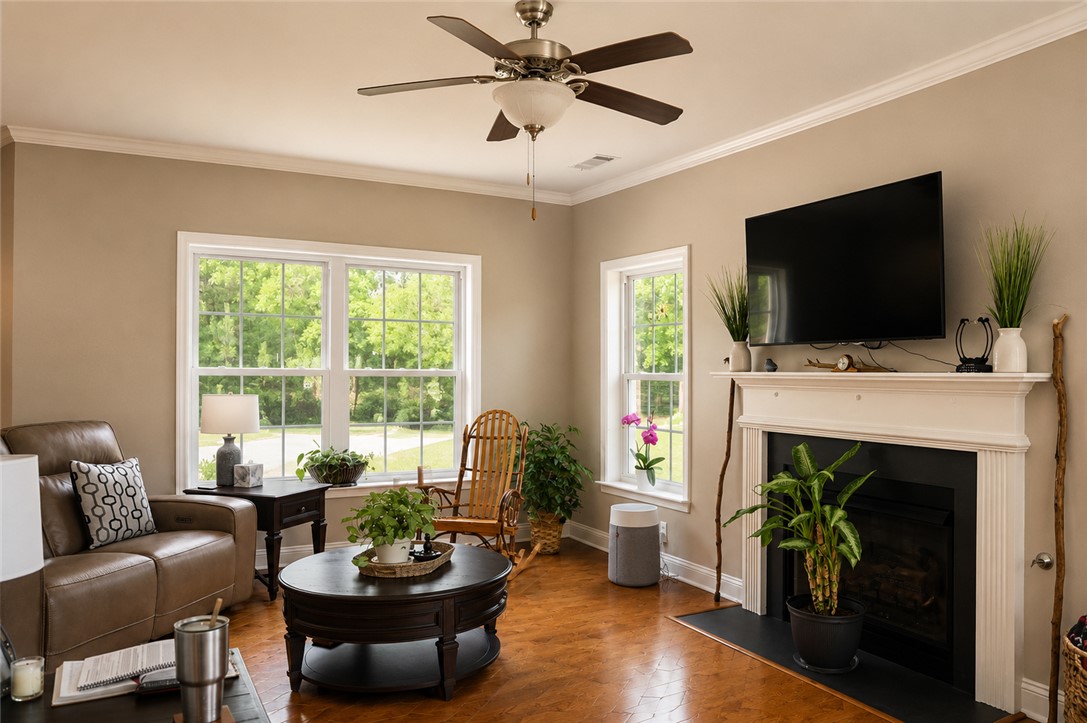 190 Fred Bradford Road Iva, SC 29655 - Photo 12 of 32 This living area features a warm fireplace, rich hardwood flooring, and bright windows inviting natural light.