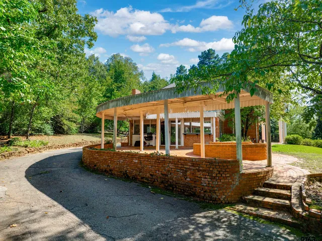 a view of a house with backyard and sitting area