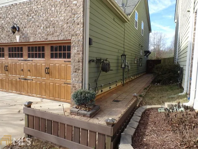 a view of a house with a small yard and wooden fence