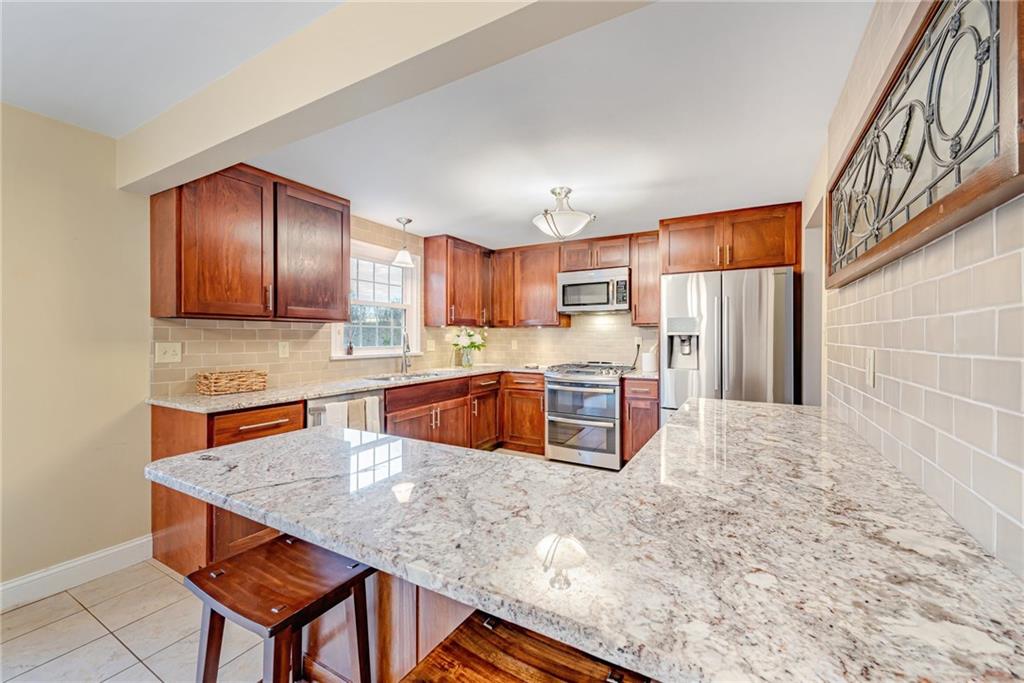 162 Hermitage Circle Ligonier, PA 15658 - Photo 9 of 38 a kitchen with stainless steel appliances granite countertop a stove a sink a refrigerator with a dining table and chairs
