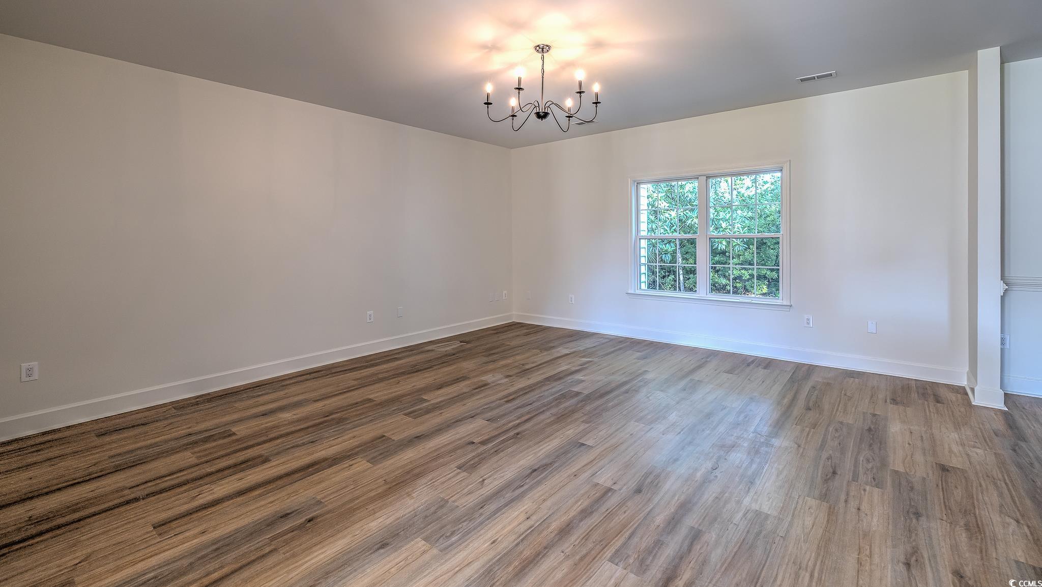 4000 Bayfield Loop Murrells Inlet, SC 29576 - Photo 12 of 33 Unfurnished room with a chandelier and wood finished floors