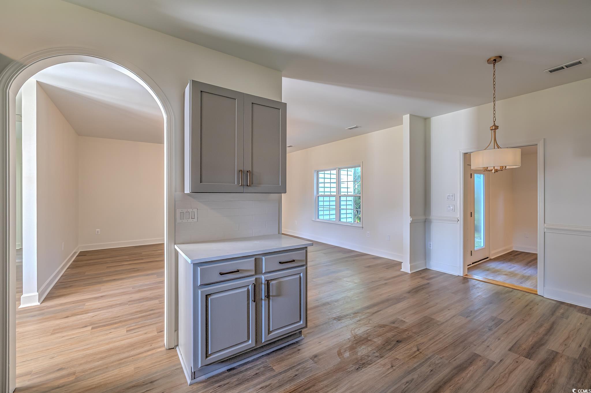 4000 Bayfield Loop Murrells Inlet, SC 29576 - Photo 24 of 33 Kitchen featuring gray cabinetry, light wood-style flooring, light countertops, and arched walkways