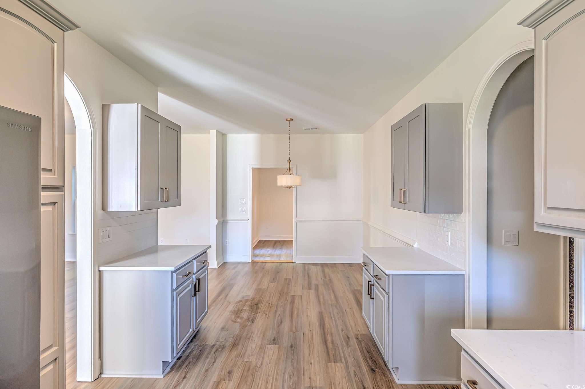 4000 Bayfield Loop Murrells Inlet, SC 29576 - Photo 25 of 33 Kitchen with gray cabinetry, light countertops, and backsplash