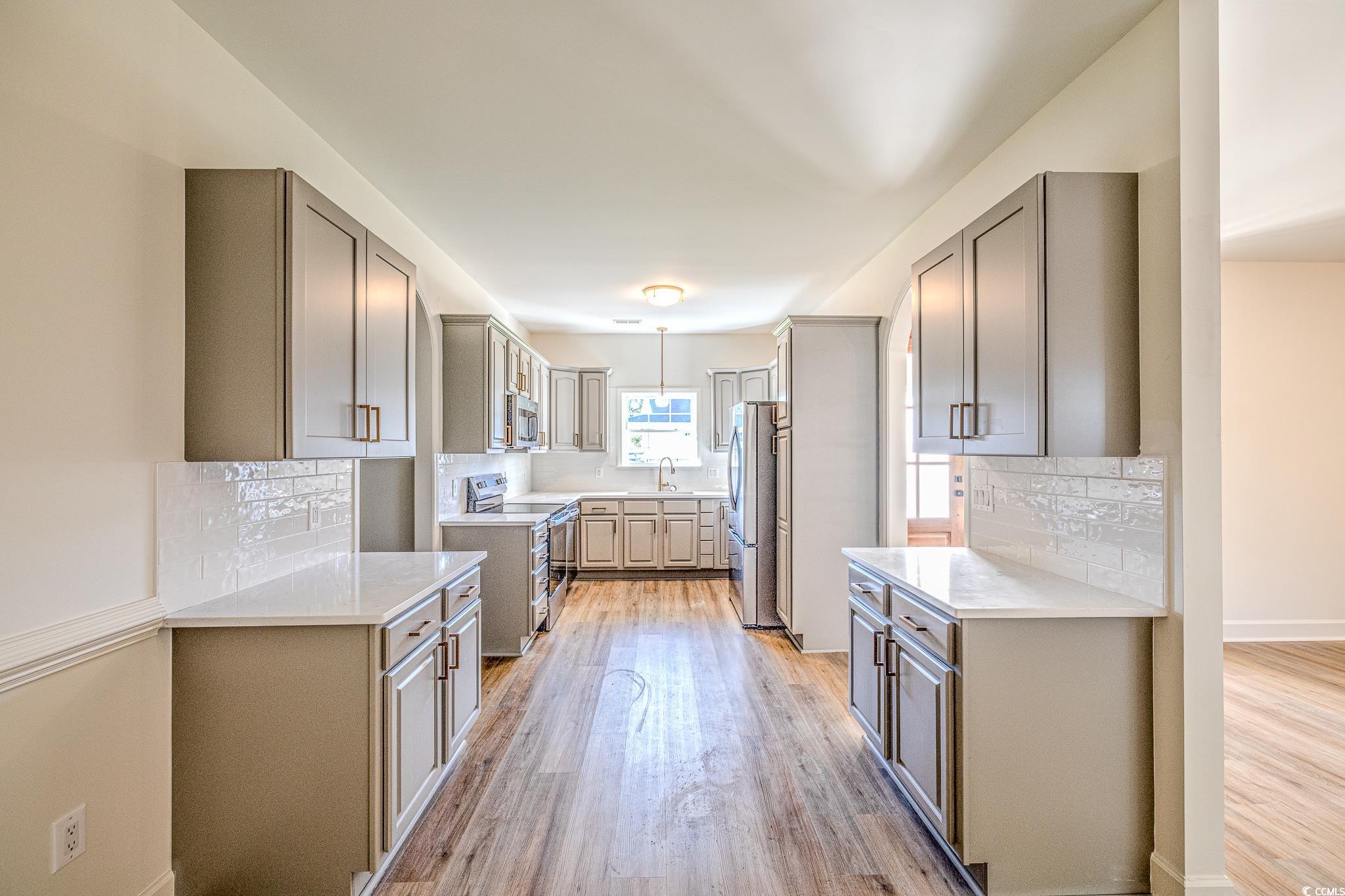 4000 Bayfield Loop Murrells Inlet, SC 29576 - Photo 26 of 33 Kitchen with stainless steel appliances, gray cabinetry, light wood-style flooring, and backsplash