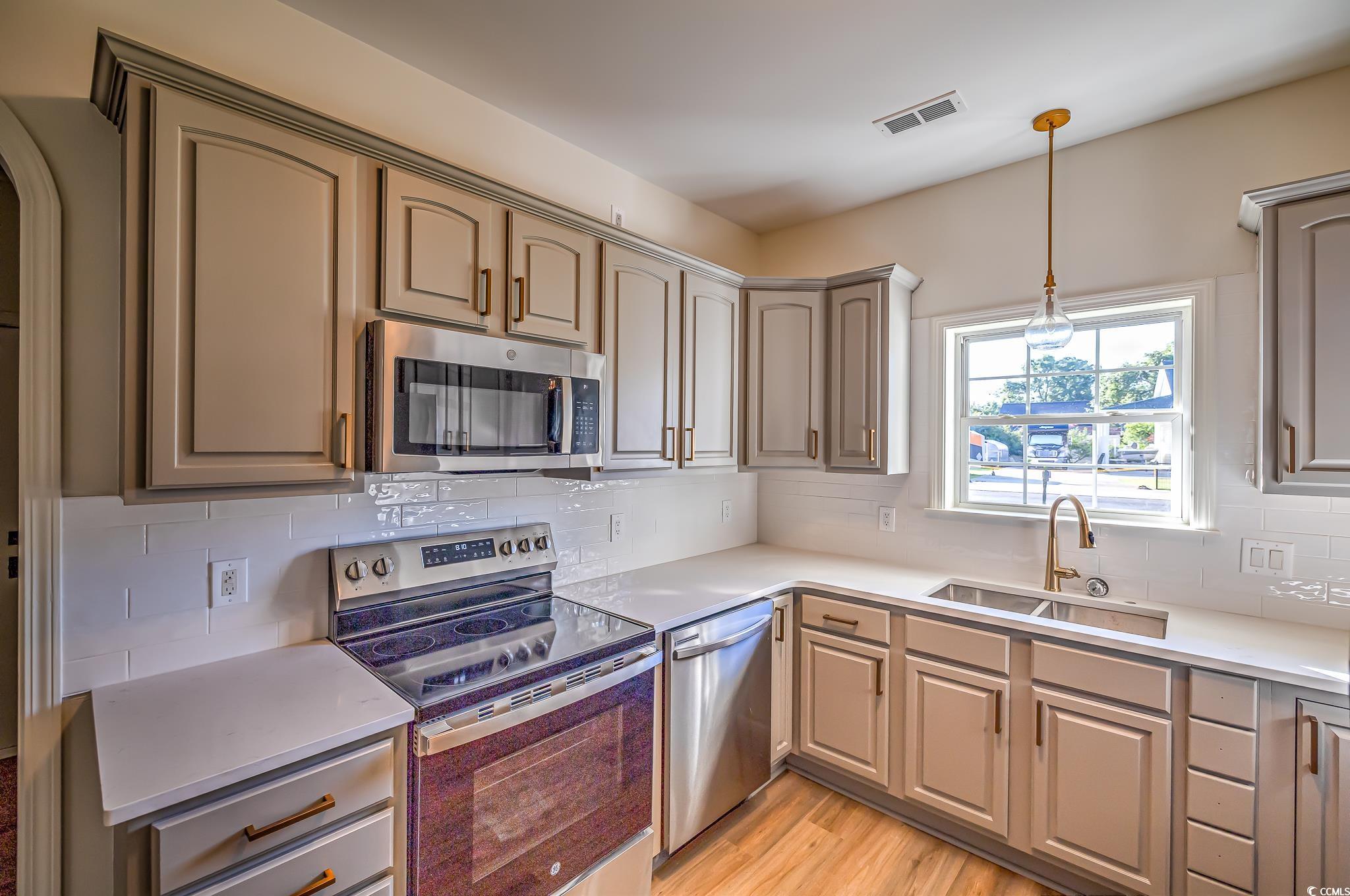 4000 Bayfield Loop Murrells Inlet, SC 29576 - Photo 28 of 33 Kitchen featuring appliances with stainless steel finishes, light countertops, hanging light fixtures, and tasteful backsplash