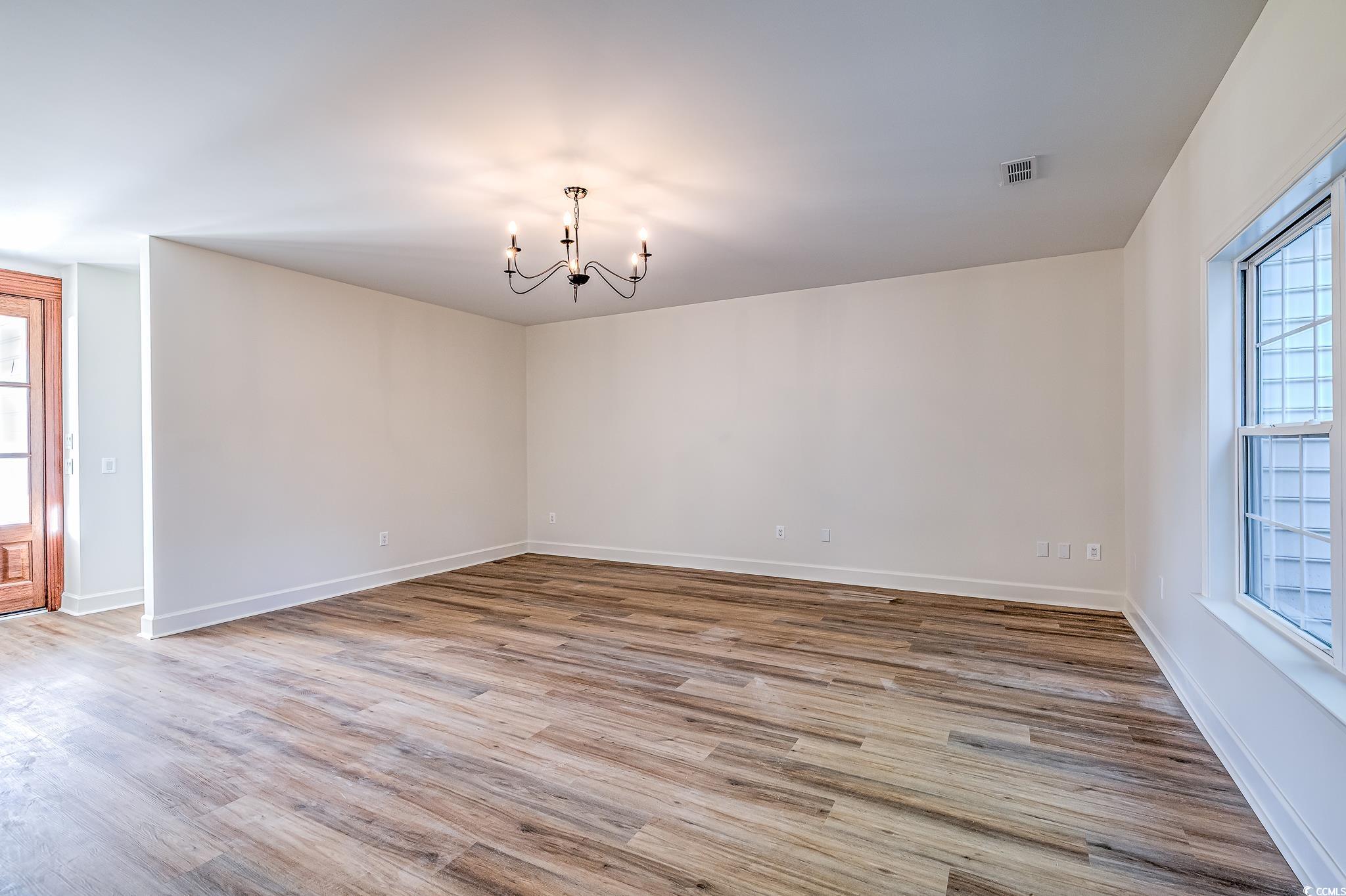 4000 Bayfield Loop Murrells Inlet, SC 29576 - Photo 29 of 33 Unfurnished room with a chandelier and wood finished floors