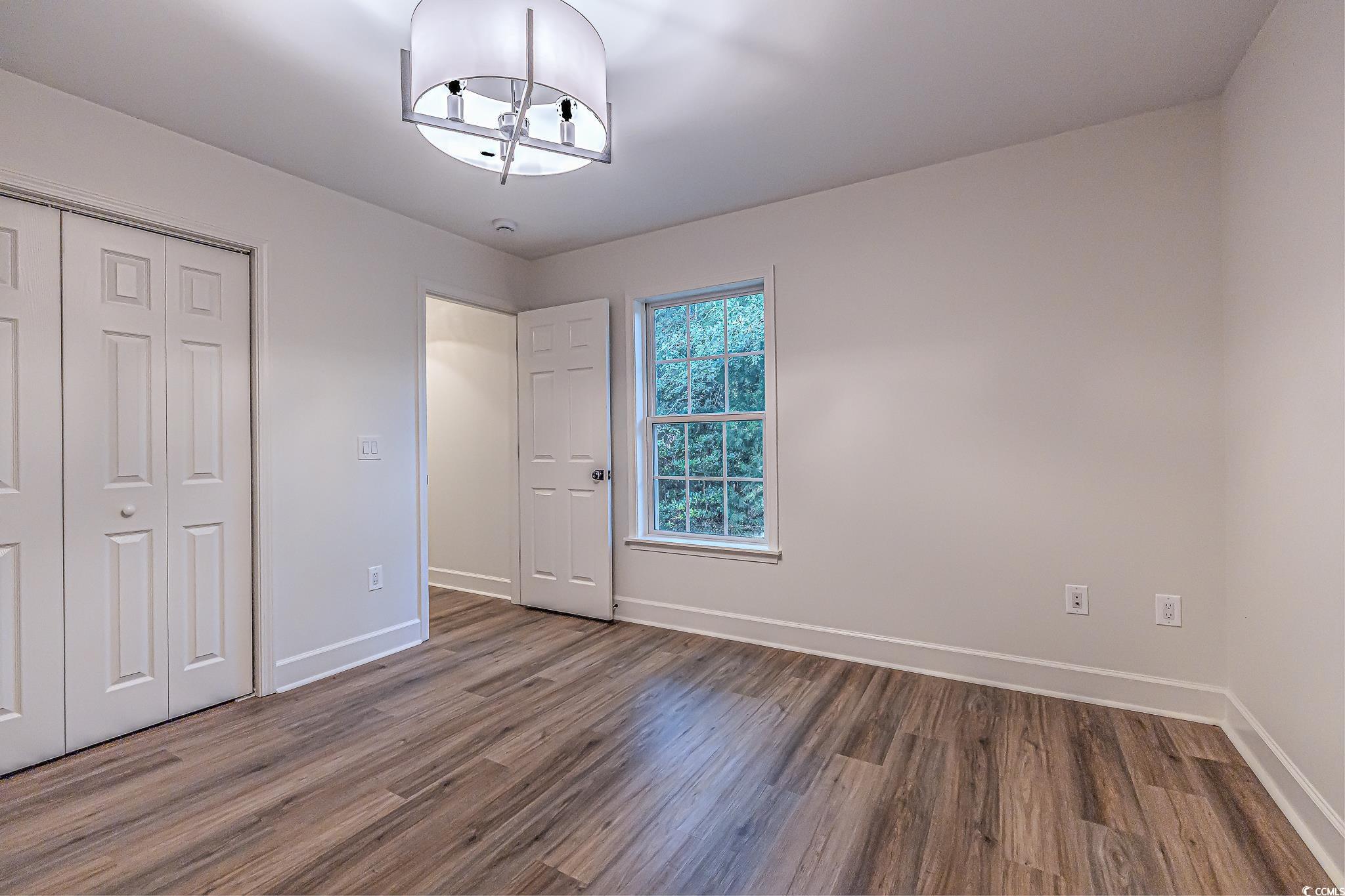 4000 Bayfield Loop Murrells Inlet, SC 29576 - Photo 31 of 33 Unfurnished bedroom with wood finished floors, a closet, and a chandelier