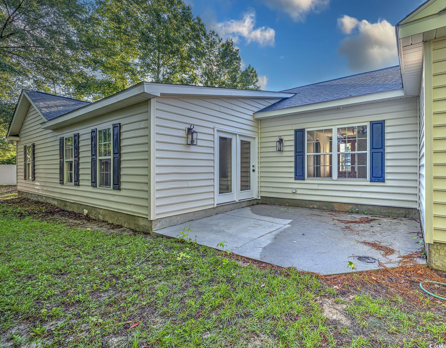 4000 Bayfield Loop Murrells Inlet, SC 29576 - Photo 6 of 33 Back of property with a patio area, roof with shingles, and a lawn